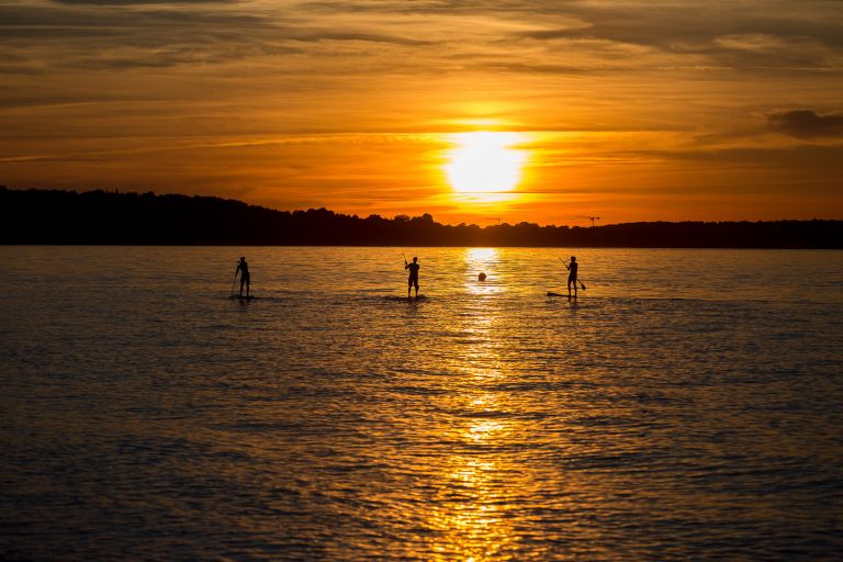 Stand Up Padler vor Niendorf im Sonnenuntergang